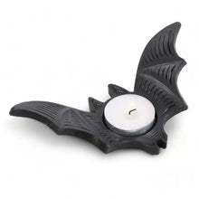 Bat-shaped tealight candle holder with round white candle and wick, black.