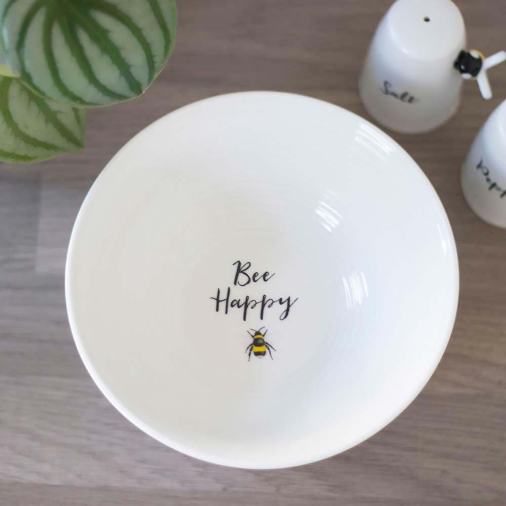 White ceramic breakfast bowl with “Bee Happy” text and small bee graphic in center.
