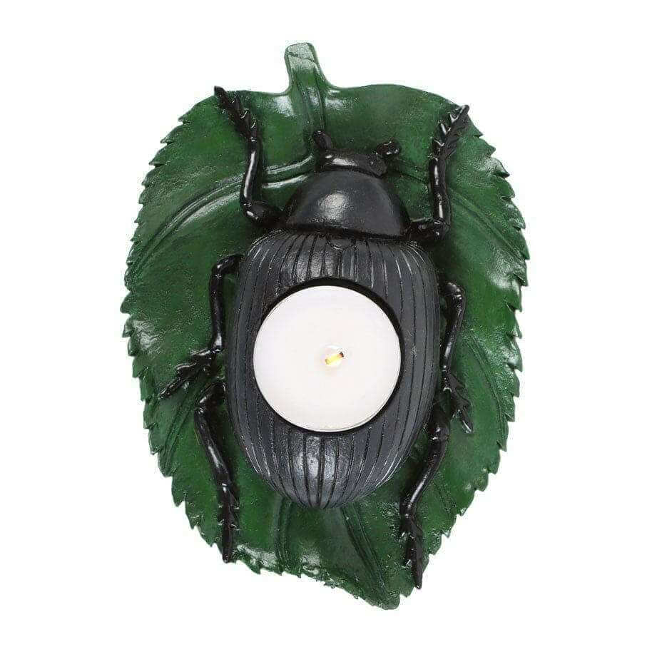 Beetle tealight candle holder, green leaf backdrop with black beetle body and centered white candle