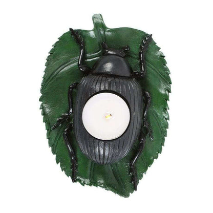 Beetle tealight candle holder, green leaf backdrop with black beetle body and centered white candle