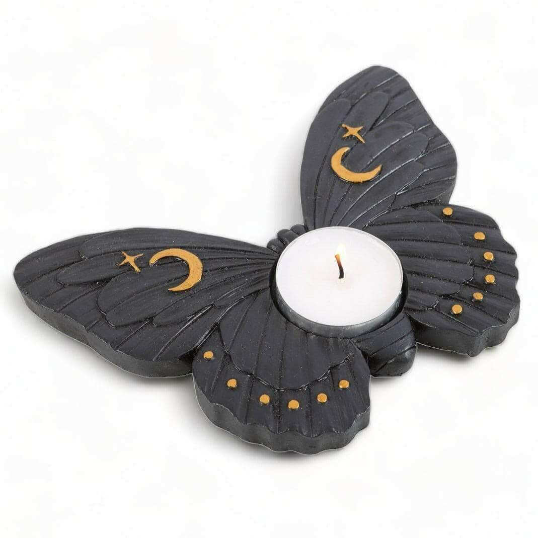 Moth tealight candle holder with layered wings, crescent moon and star details, lit candle flame