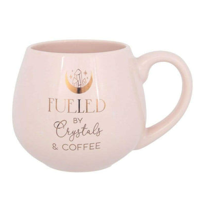 Pink rounded mug with 'FUELED by Crystals & COFFEE' text, front view