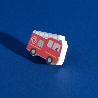 Red fire truck drawer knob on cream base with swirl detail and dark wheels