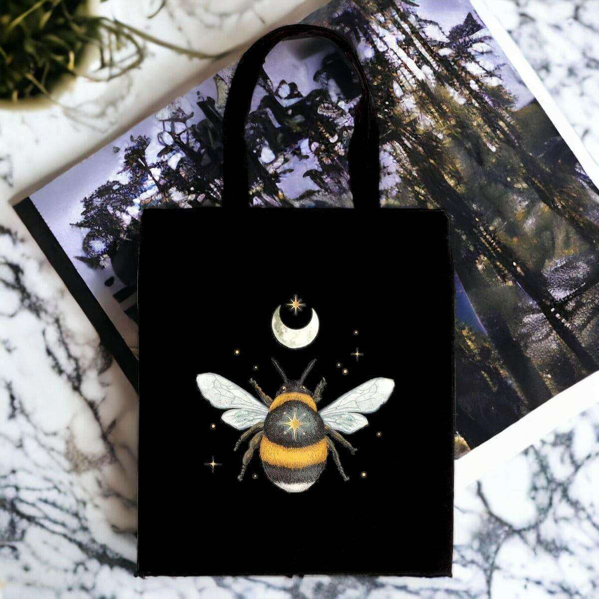 Black cotton tote bag with moon-and-bee graphic, long handles