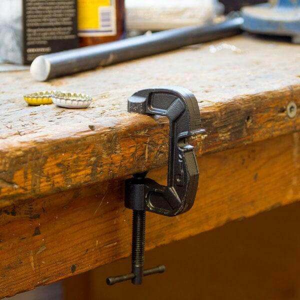 G-Clamp bottle opener clamped to a wooden beam with open-close jaw
