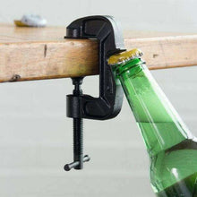 G-Clamp bottle opener clamping a green glass bottle on a wooden workbench