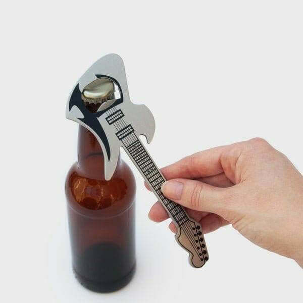 Guitar-shaped stainless steel bottle opener placed on a bottle cap