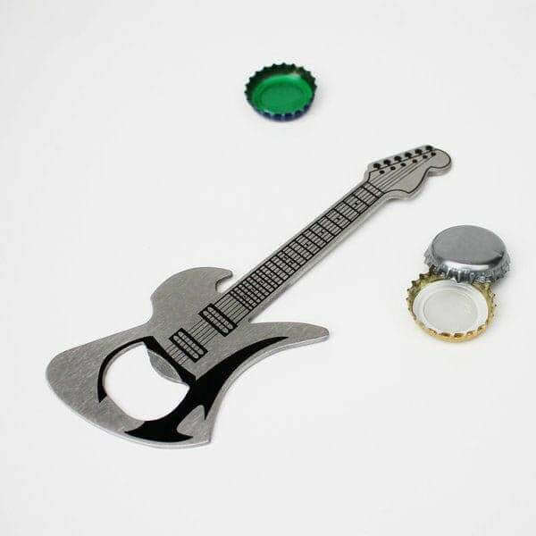 Guitar-shaped bottle opener with a green cap and bottle cap nearby
