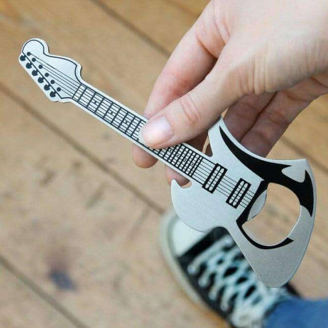 Guitar-shaped bottle opener held between fingers over a tabletop