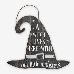 Wooden sign stating "A Witch Lives Here - With Her Little Monsters"