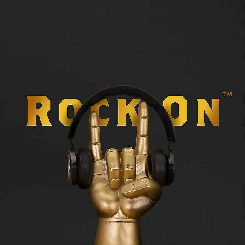Rock On headphone stand close-up with golden hand and black over-ear headphones
