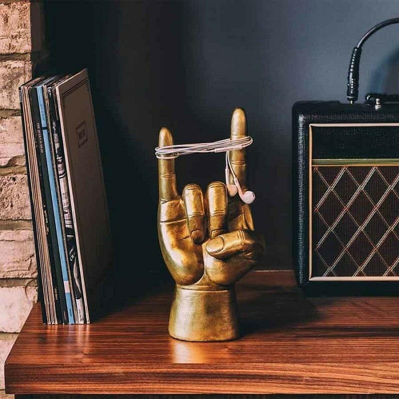 Rock On headphone stand with golden hand holding a silver headphone cable