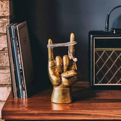 Rock On headphone stand with golden hand holding a silver headphone cable