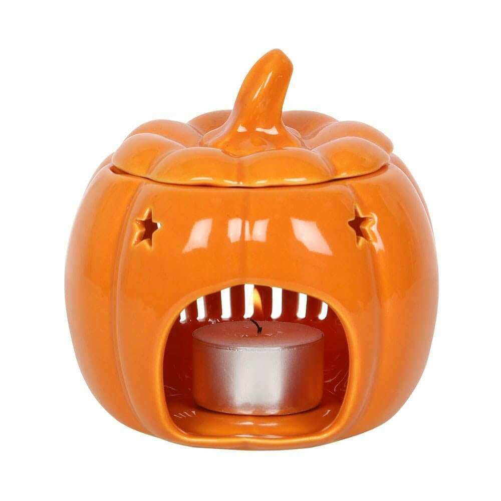 Orange pumpkin wax melt burner with star cutouts and metal candle cup, front view