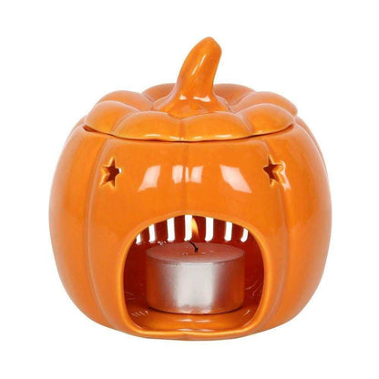 Orange pumpkin wax melt burner with star cutouts and metal candle cup, front view