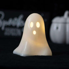 White ceramic ghost LED night light with three glowing eyes, lit from inside.