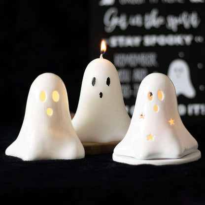 Set of three white ceramic ghost LED night lights, one lit with candle flame.