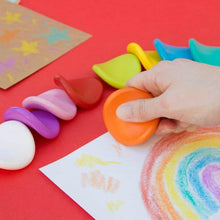 Jumbo grip crayons held in a hand, with bright orange, yellow, green, and blue tips.