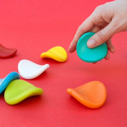 Jumbo grip crayons scattered in bright colors; hand holds a teal crayon.