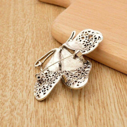 Silver-tone butterfly brooch pin with white rhinestone wings and black dot detail