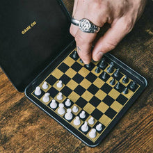Magnetic travel chess set with magnetic pieces on foldable black board case