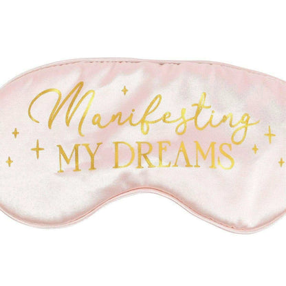 Satin sleep eye mask close-up with “Manifesting My Dreams” gold script and stars