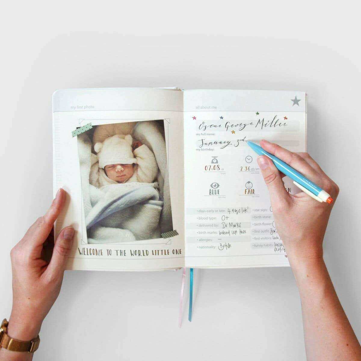 Baby years journal opened to newborn photo and labeled notes, with teal pen marking