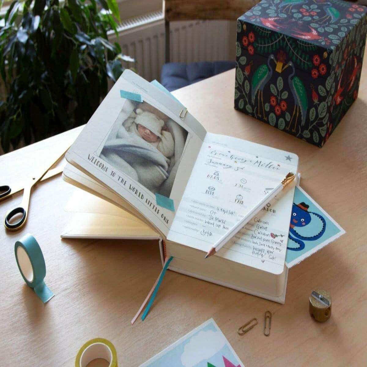 Baby years journal open with a baby photo card and matching notes page