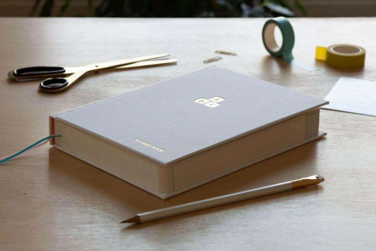 Baby years journal with light cover and emblem, closed on a desk