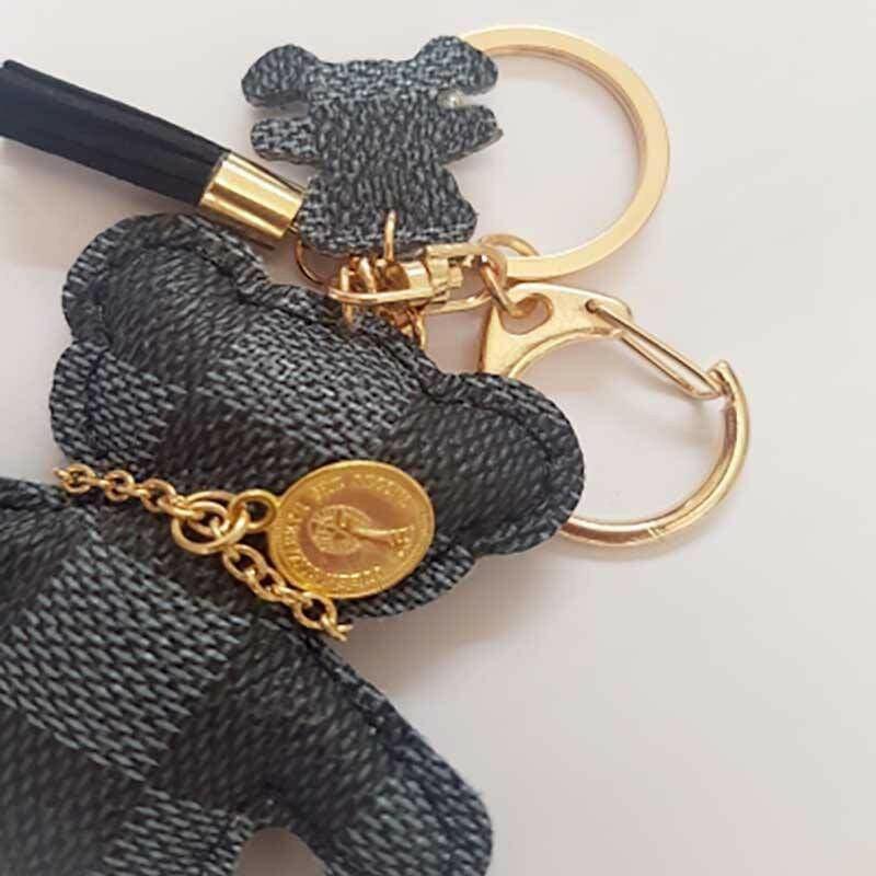 Close-up dark patchwork teddy bear keyring with gold chain and round coin charm