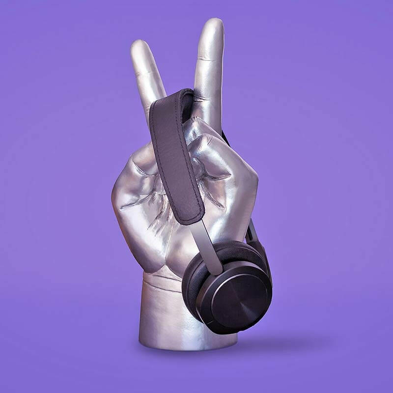 Metallic hand-shaped headphone stand with black strap and headband