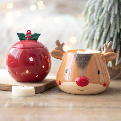 Red bauble oil burner with lit wax melt base, next to a deer-shaped warmer