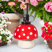 Red polka-dot plant mister with black pump and angled spray tube on a white mushroom base
