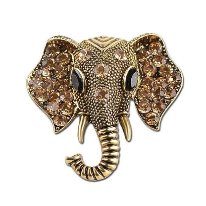 Gold elephant brooch with amber-toned crystal clusters and striped trunk, front