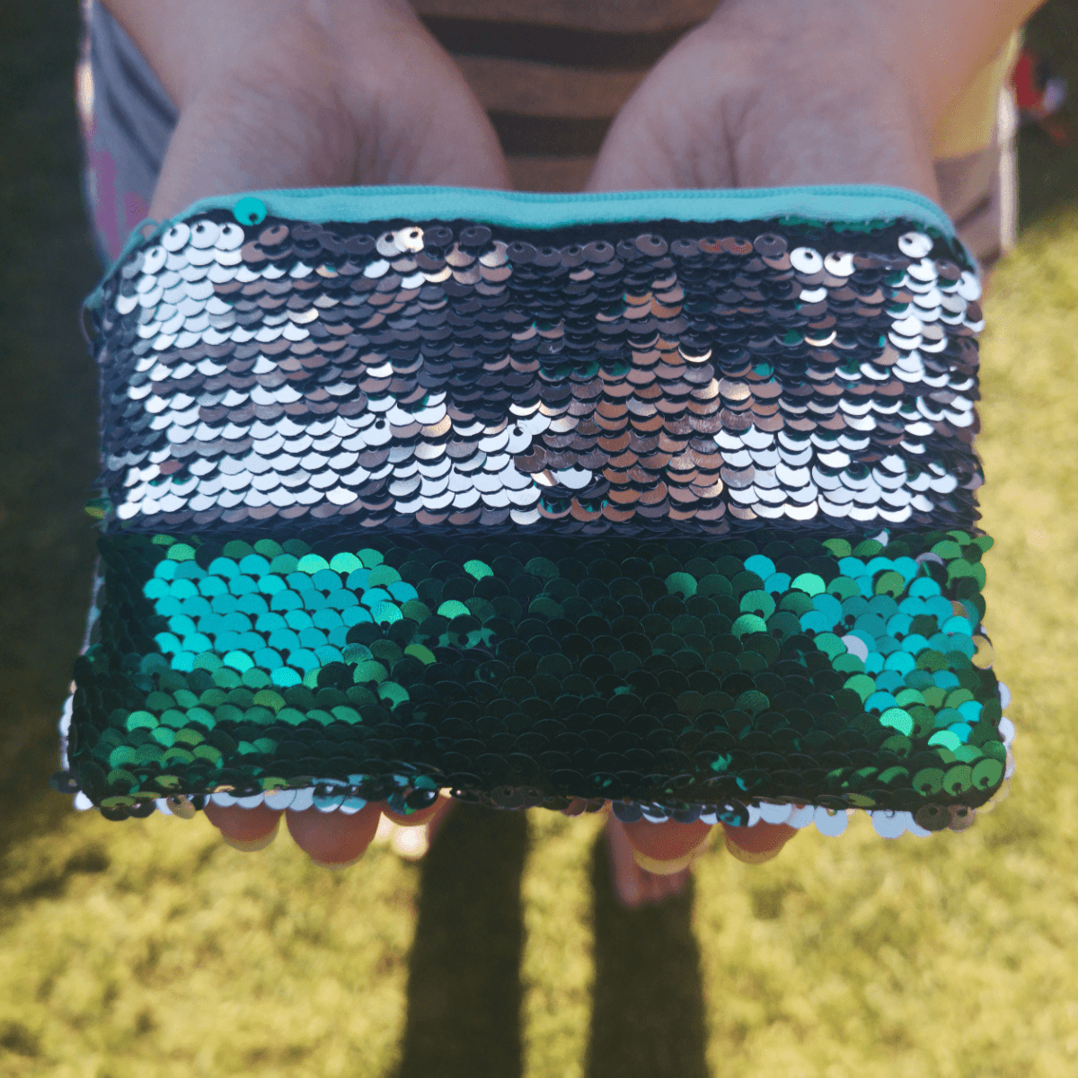 Reversible sequin coin purse with zip, blue and green two-sided scallop texture.