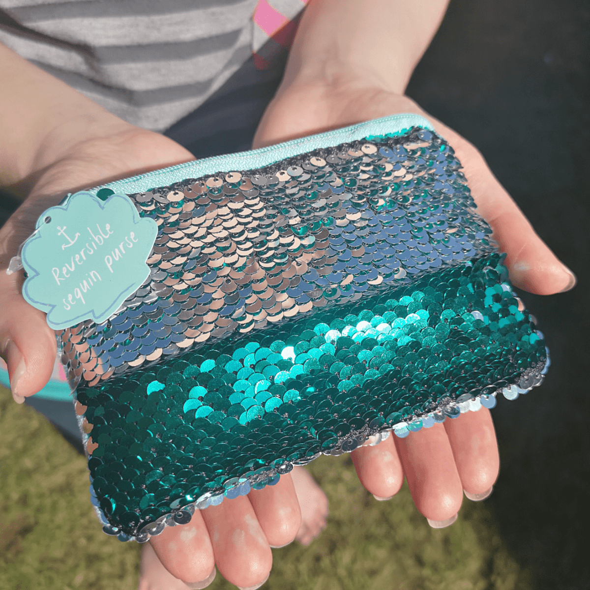 Reversible sequin coin purse with zip, teal front with silver sequin pattern.