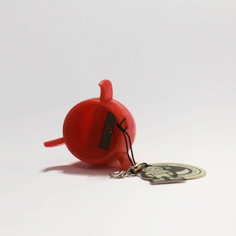 Red rocket pencil sharpener with exposed blade and attached keychain charm.