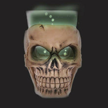 Skull mini shot glass with clear cup filled with green liquid and tan skull face