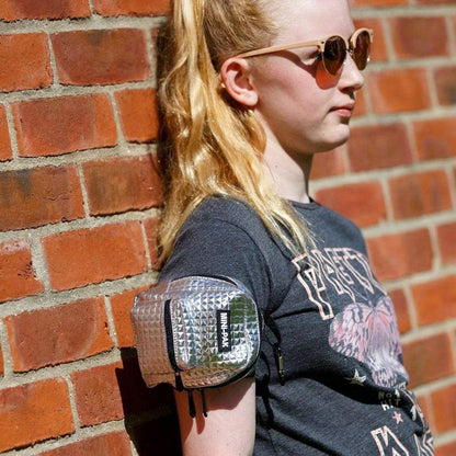 Silver mini backpack worn on arm with black trim and front logo patch