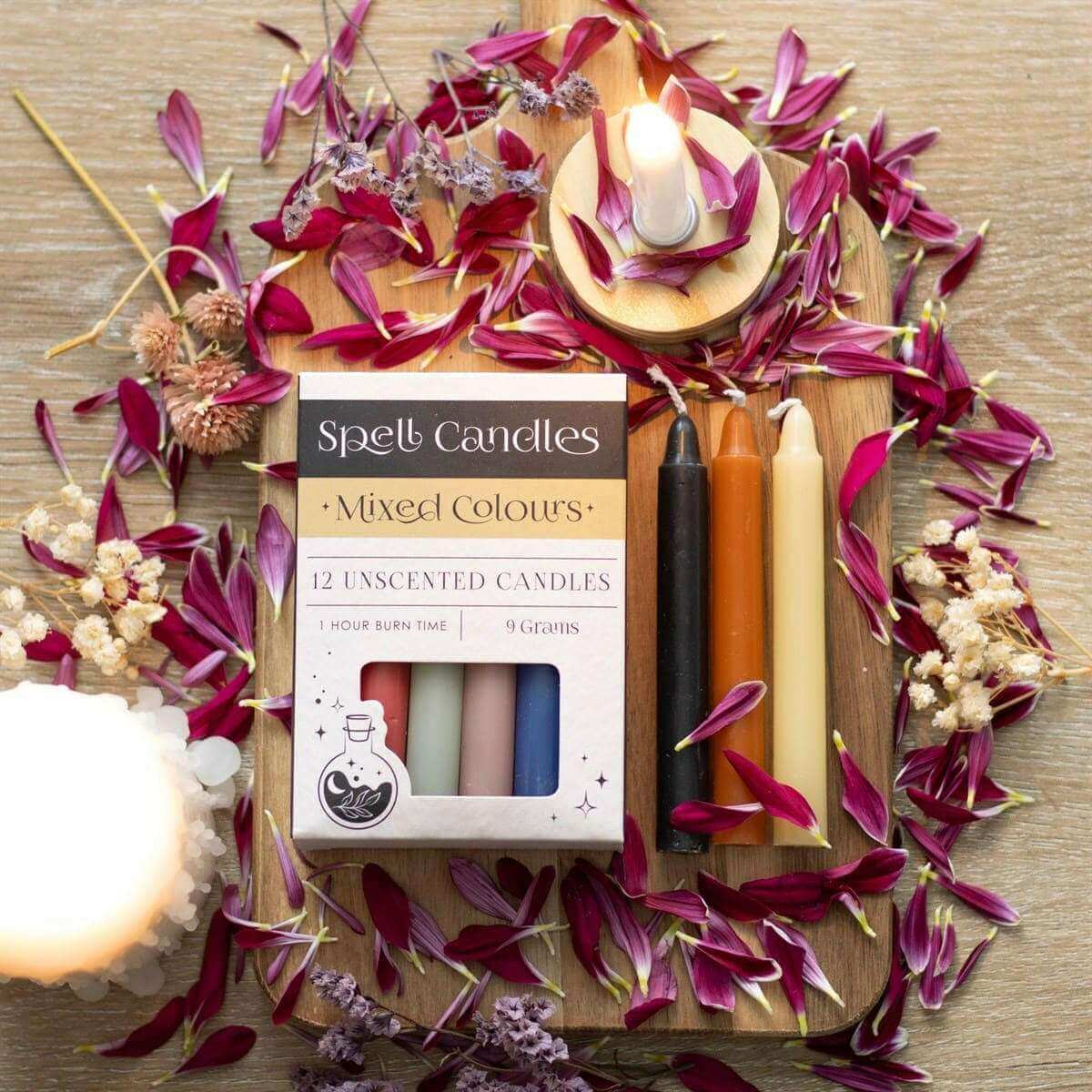 Spell candles set with lit wicks; open box showing mixed-color uncented candles