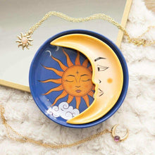 Round trinket dish with blue rim and sun-and-moon illustration, closed eyes and clouds