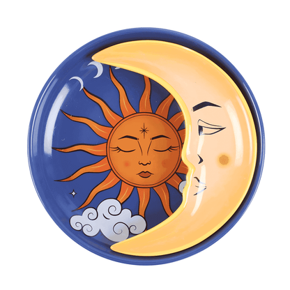 Round ceramic trinket dish showing crescent moon with orange sun face and closed eyes