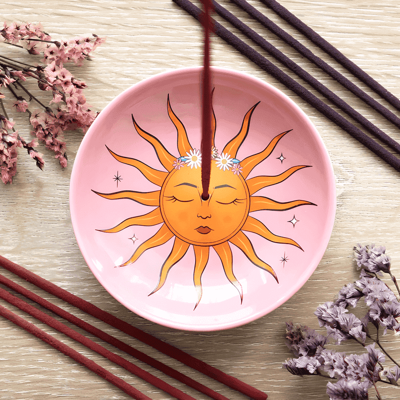 Pink ceramic incense holder with smiling sun face and tarot-style rays