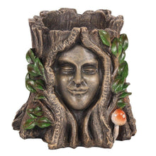 Decorative plant pot with bronze face, green leaves and small red mushroom detail