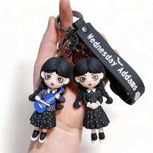 3D keyring charm with two Wednesday-style doll figures and black clasp strap