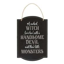 Black arched hanging sign with white witch quote text