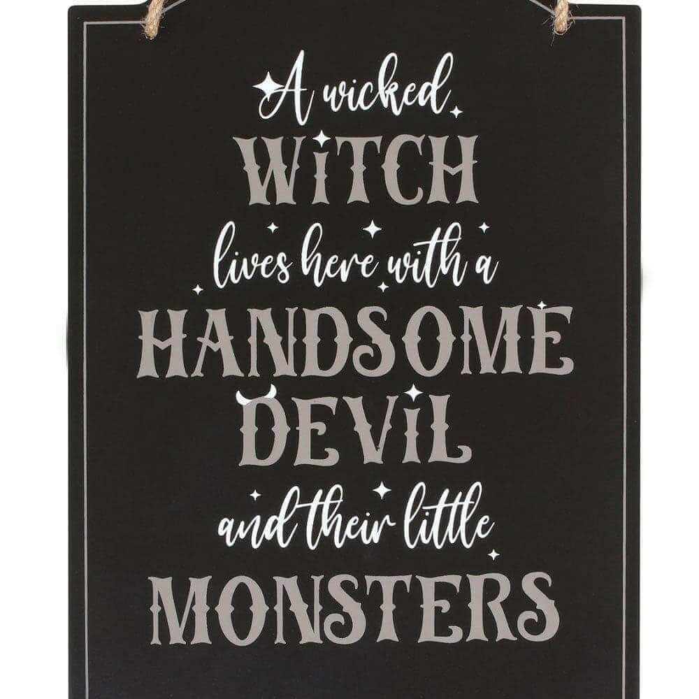 Black hanging sign close-up with white "Wicked Witch" quote