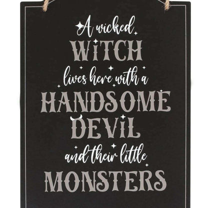 Black hanging sign close-up with white "Wicked Witch" quote