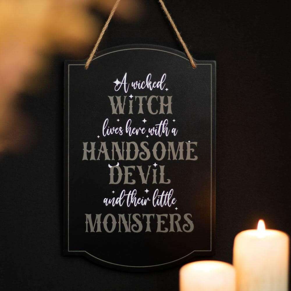 Black hanging sign with white witch lettering and top loop rope