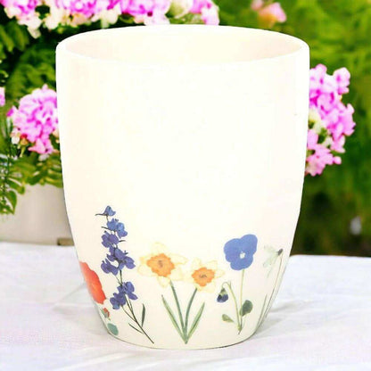 White ceramic plant pot with blue and purple wildflowers and orange flower print